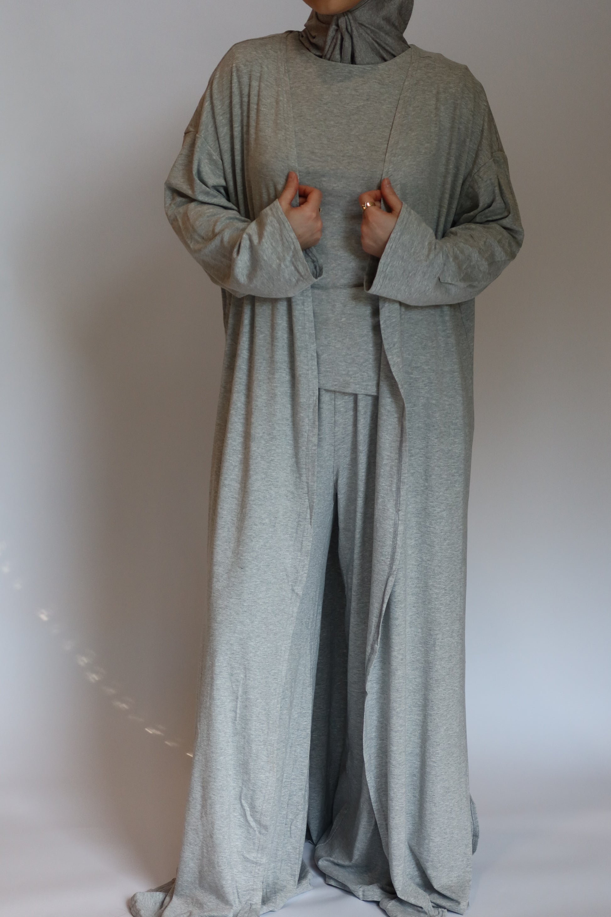 Person wearing a gray outfit against a plain background